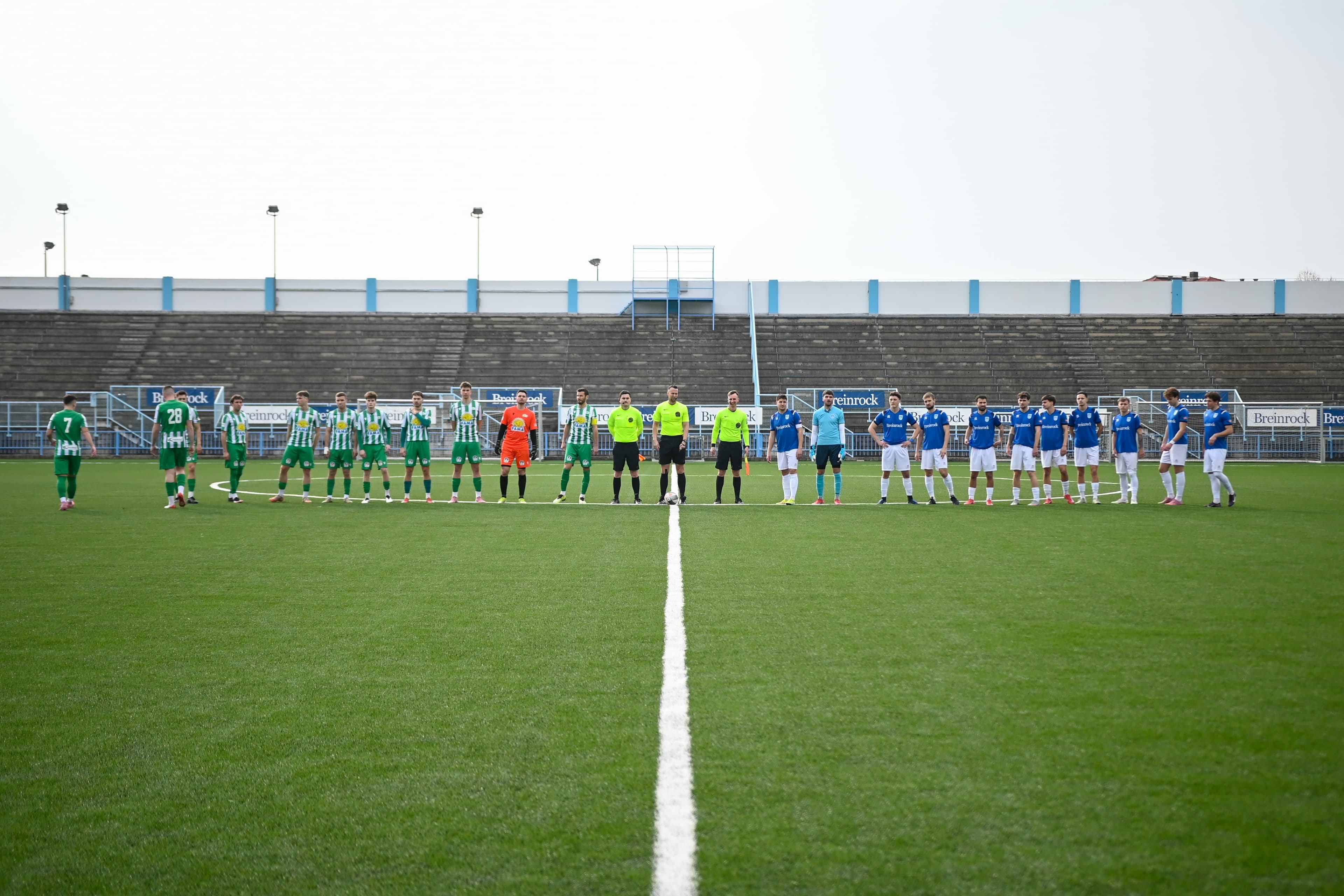 NK Izola in gostujoča ekipa, postrojeni na sredini igrišča pred začetkom tekme na Stadionu Drvarski